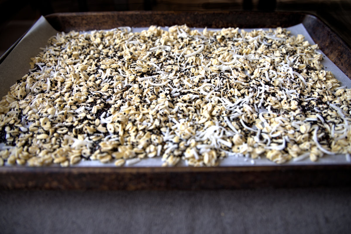 sheet pan of coconut, quinoa, and oats to toast for homemade granola